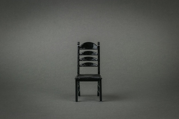 Stylish black chair on a gray background. A stylish piece of furniture. A place for your text.