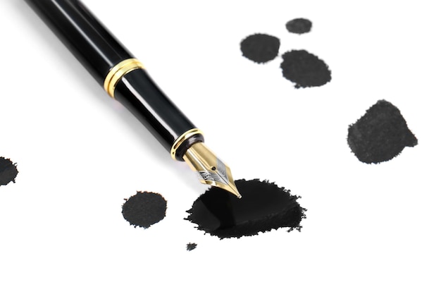 Stylish black fountain pen and blots of ink isolated on white