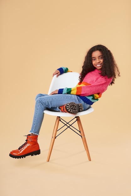 Stylish black girl resting on chair