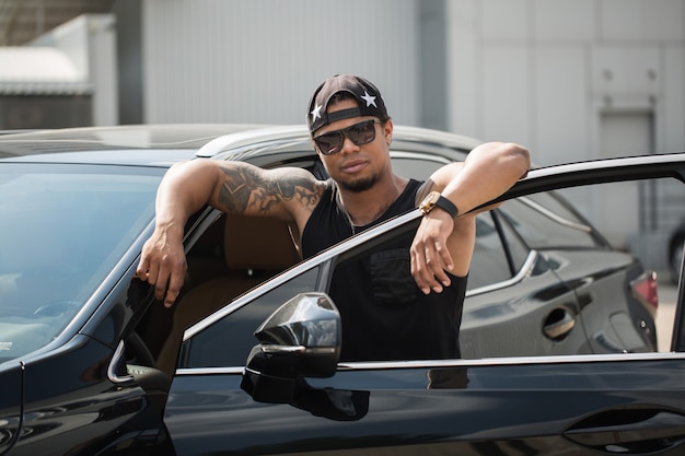Photo stylish black man, standing beside his fancy car