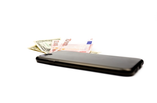 Stylish black smartphone on a background of heaps of money. Isolate on a white background.