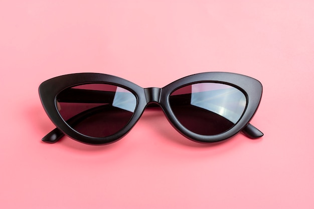 Stylish black sunglasses isolated on trendy pink