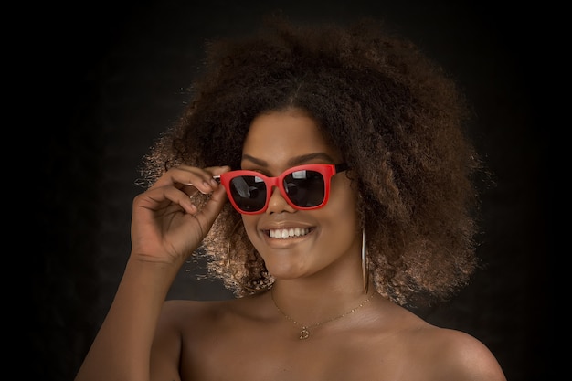 Stylish black woman in red sunglasses