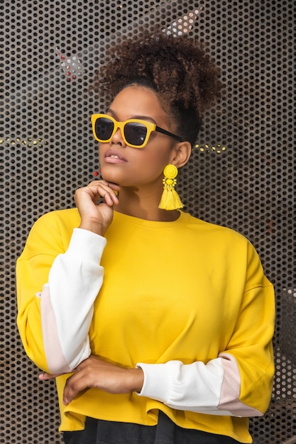 Stylish black woman in yellow outfit