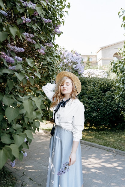 Stylish blonde woman in a blossoming garden