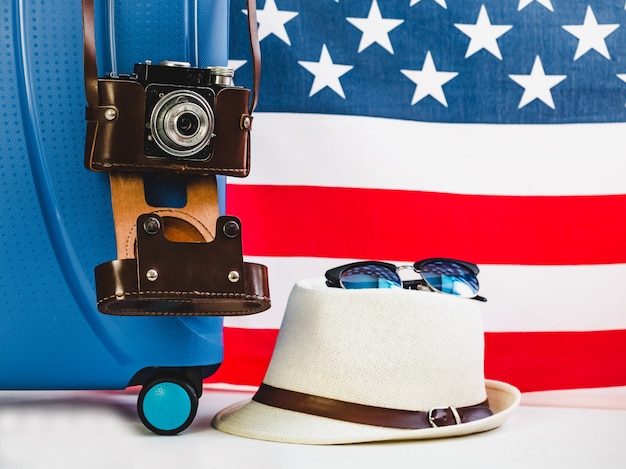 Foto elegante, blu valigia, bandiera usa e macchina fotografica d'epoca