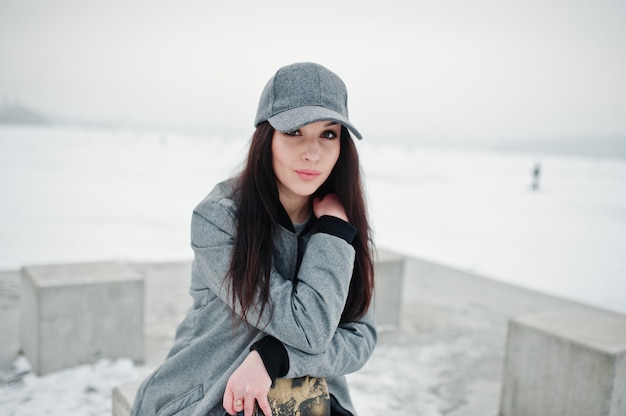 Stylish brunette girl in gray cap on winter day.