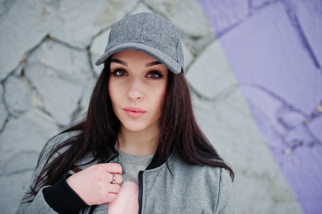 Stylish brunette girl in gray cap