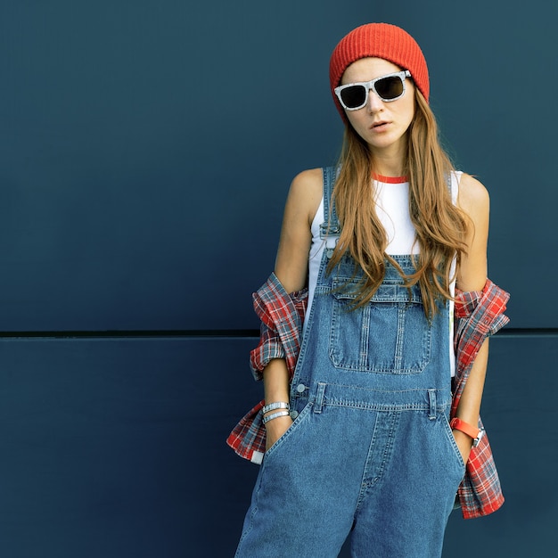 Stylish brunette in red hat and denim in urban locations