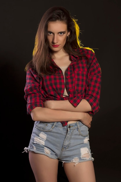 Stylish brunette woman posing in fashionable clothes at studio