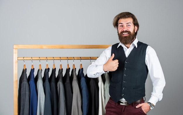 Elegante uomo d'affari nell'area di lavoro studio di design di moda stilista maschile misure individuali mano dell'uomo uomo che ordina tailleur in posa al coperto il sarto misura l'uomo