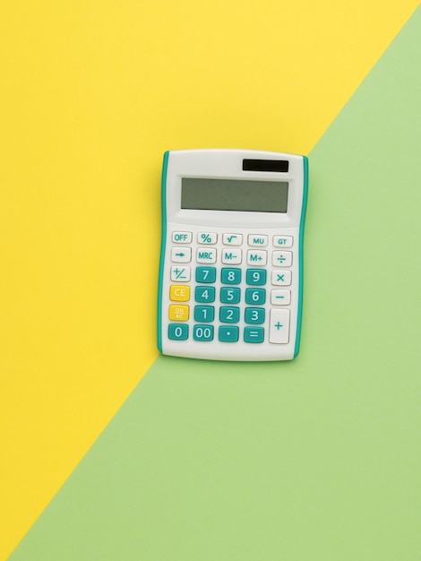 Stylish calculator on a yellow and green background. Minimal accounting concept.