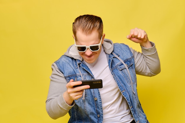 Stylish Caucasian man in a jeans on yellow