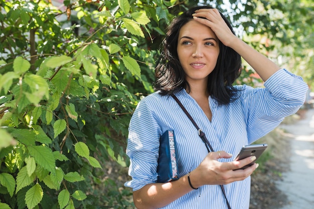 Stylish Caucasian woman using online communication with free wireless internet connectionon her webenabled smart phone to navigate gps Lifestyle business and people concept