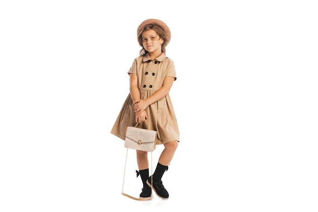 Stylish childhood portrait of little girl kid in vintage clothes posing isolated over white studio