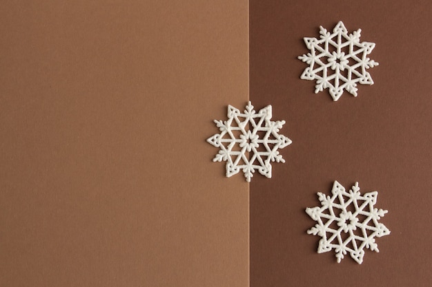 Stylish christmas composition white snowflakes on a brown and beige background copy space