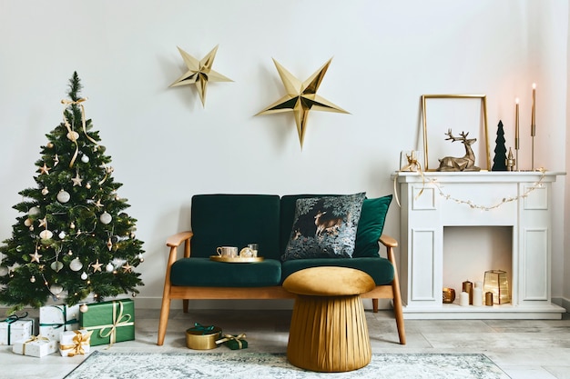 緑のソファ、白い煙突、クリスマスツリーと花輪、星、ギフト、装飾が施されたスタイリッシュなクリスマスのリビングルームのインテリア。家族の時間。レンプレート。