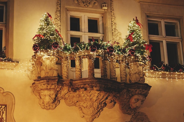 Foto eleganti rami di alberi di natale ornamenti rossi nelle luci illuminazione sul balcone dell'edificio in serata atmosferico momento magico decorazioni natalizie per le vacanze invernali buon natale