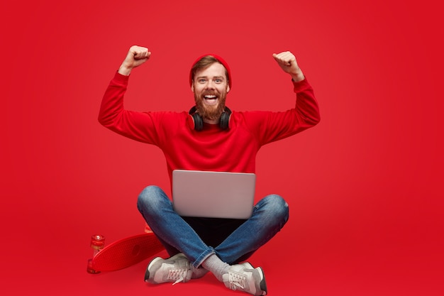 Stylish coder with laptop celebrating success