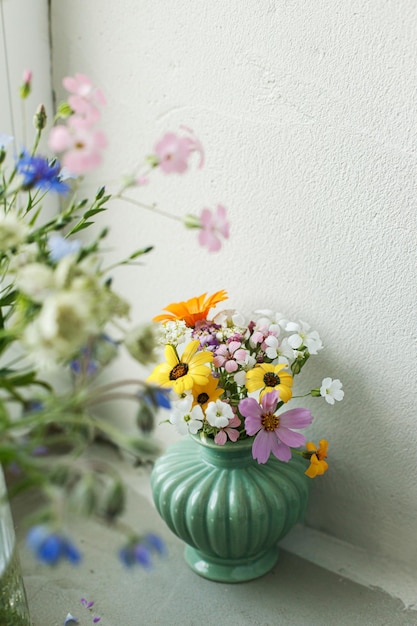 写真 素朴な壁の背景のタイル棚にスタイリッシュなカラフルな野生の花の花束自宅のモダンな部屋の庭のフラワーアレンジメントから集めた花瓶の美しい夏の花