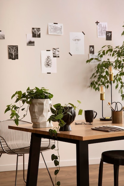 L'elegante composizione di interni accoglienti dell'ufficio con sedia in metallo tavolo in legno piante foto e accessori personali modello di arredamento per la casa