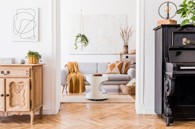 Stylish composition of creative spacious apartment interior with grey sofa, coffee table, plants, carpet and beautiful accessories. White walls and parquet floor.