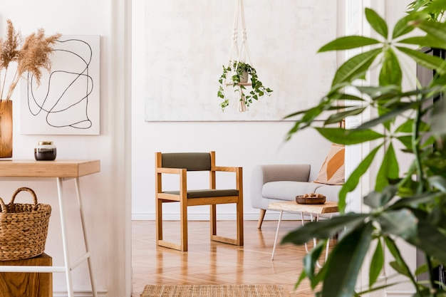 Stylish composition of creative spacious apartment interior with grey sofa, coffee table, plants, carpet and beautiful accessories. White walls and parquet floor.