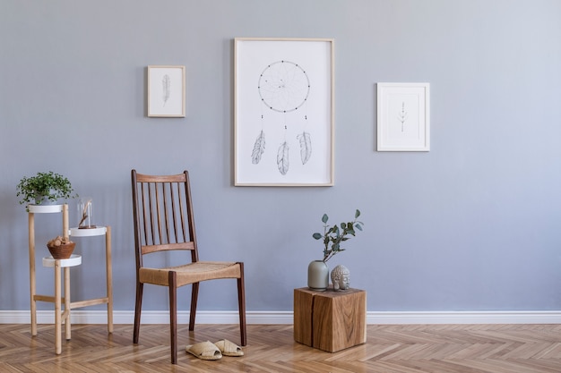 Stylish composition of creative spacious living room interior with mock up poster frame, chair, plants and accessories. Grey walls and parquet floor. Boho style. Template