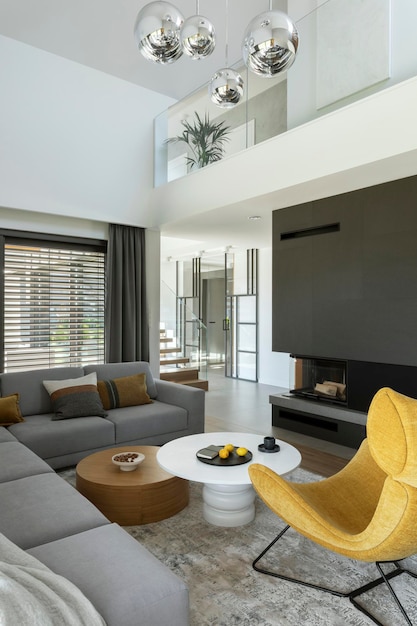 Stylish composition of living room interior with corner beige
sofa, yellow armchair, coffee table and minimalist accessories.
panoramic winow. template.