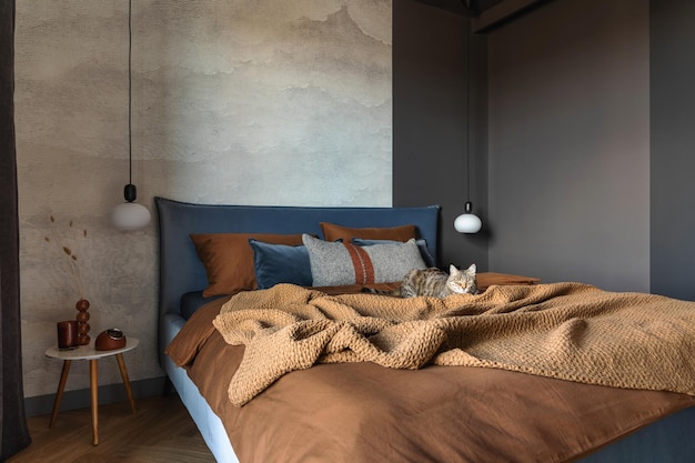 Stylish composition of modern bedroom interior bed creative\
lamp and elegant personal accessories concrete wall brown sheeets\
minimalistic masculine concept template