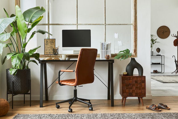 Стильная композиция интерьера современного мужского домашнего офиса с черным промышленным столом, коричневым кожаным креслом, компьютером и стильными личными аксессуарами. Шаблон.