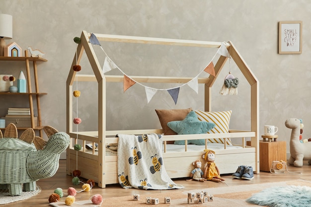 아늑한 스칸디나비아 어린이 방 인테리어의 세련된 구성은 나무 침대, 선반, 봉제 인형, 나무 장난감, 직물 장식으로 꾸며져 있습니다. 중립적 인 창조적 인 벽, 바닥에 카펫. 주형.