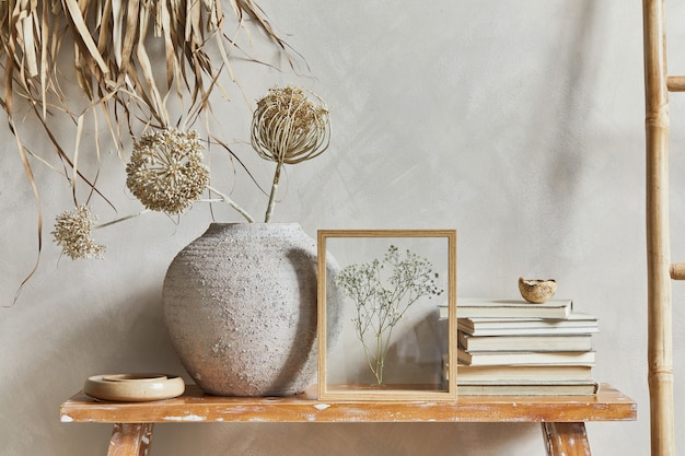 写真 コピースペース、レトロなスタイルのベンチ、粘土の花瓶と食器を備えたリビングルームのインテリアのスタイリッシュな構成。素朴なインスピレーション。夏の雰囲気。ベージュの壁。レンプレート。