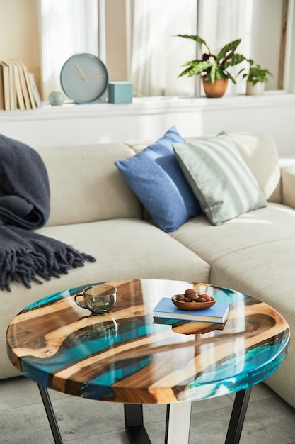 デザインエポキシコーヒーテーブル、ソファ、毛布、枕、本、装飾、現代の家の装飾品を使ったスタイリッシュな構成。詳細。