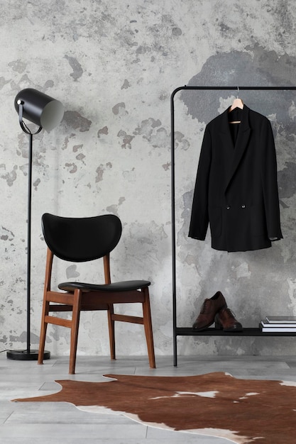 The stylish compostion at living room interior with concrete wall chair hanger with clothes and elegant personal accessories Loft and industrial interior Template xD