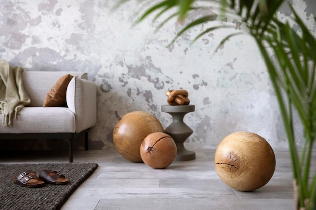 The stylish compostion at living room interior with design gray\
sofa wooden ball coffee table and elegant personal accessories loft\
and industrial interior home decor template xd