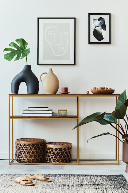 Stylish concept of living room interior with frames, wooden console, tropical leaf in vase, rattan baskets, plant, carpet and personal accessories in home decor.