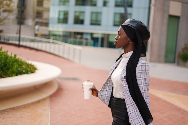 Donna di colore sicura ed elegante che ha pausa caffè