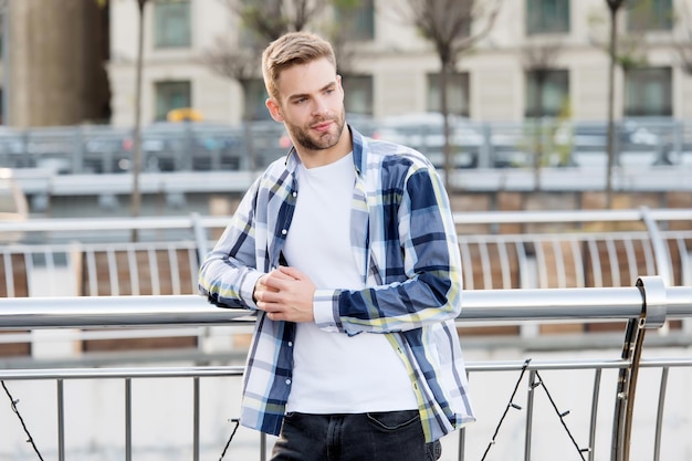 Stylish, cool and contemporary. Confident man lean on railing urban outdoors. Fashionable style. Casual fashion trend. Mens wardrobe for summer. Fashionable menswear. Affordable fashionable clothing.