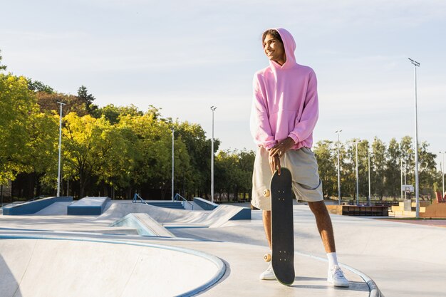 Stylish cool teen male skateboarder at skate park