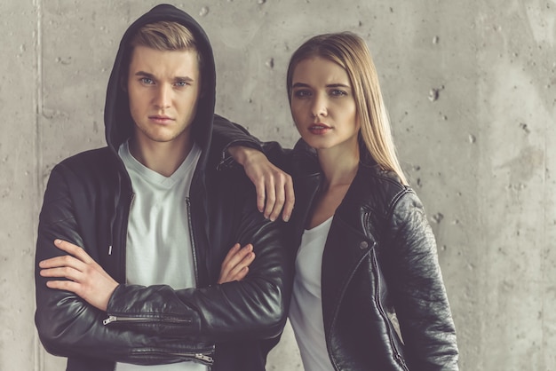 Stylish couple in leather jackets is looking at camera.