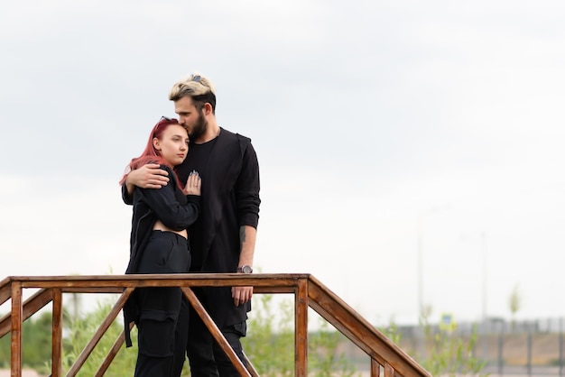 Photo stylish couple in love in black clothes are walking in the park and hugging lovely hipster couple enjoying time together youth love and lifestyle concept