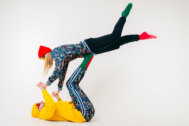 Stylish couple of man and woman in colorful clothes posing  over white background