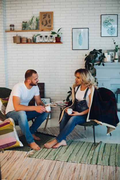 Stylish couple sitting on bad and embracing stomach