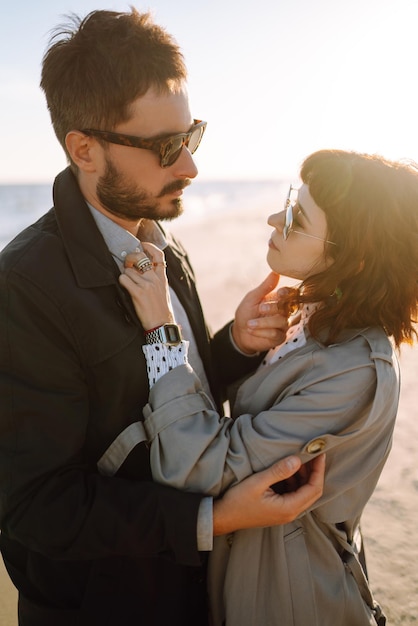 Stylish couple walking and hugging by the sea Lovely hipster couple enjoying time together