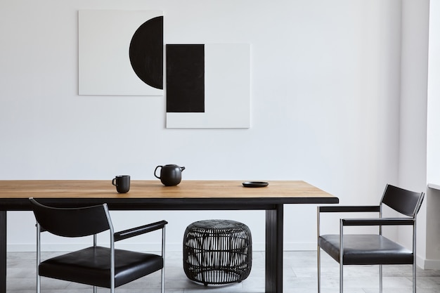 デザインの木製の家族のテーブル、黒い椅子、マグカップ付きのティーポット、壁のモックアップアート絵画、モダンな家の装飾のエレガントなアクセサリーを備えたスタイリッシュなダイニングルームのインテリア。レンプレート。