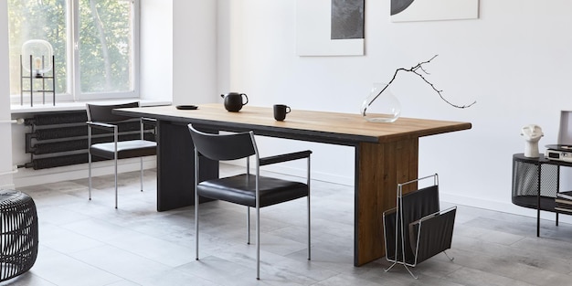 Стильный интерьер столовой с дизайнерским деревянным семейным столом, черными стульями, чайником с кружкой, макетами художественных картин на стене и элегантными аксессуарами в современном домашнем декоре. Шаблон.