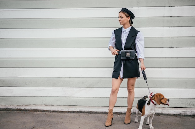 Stylish dog trainer with Beagle on street