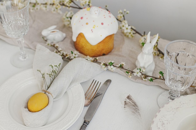 Стильная сервировка пасхального бранча пасхальное яйцо в кроличьей салфетке современные цветы кулича