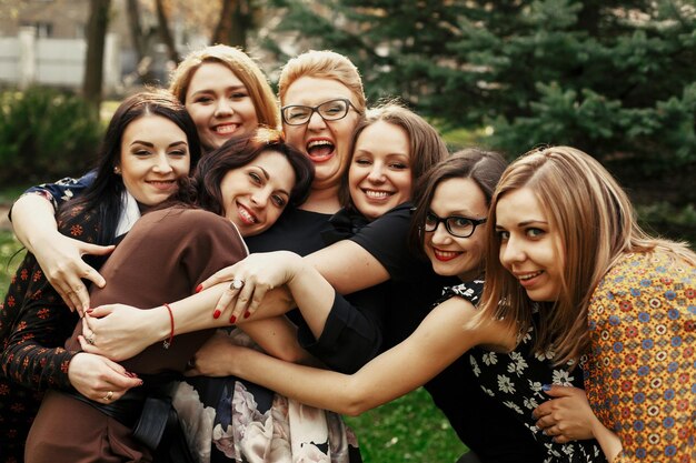 Foto donne eleganti ed eleganti che si divertono alla celebrazione nel concetto di momento divertente del parco soleggiato che si riunisce insieme